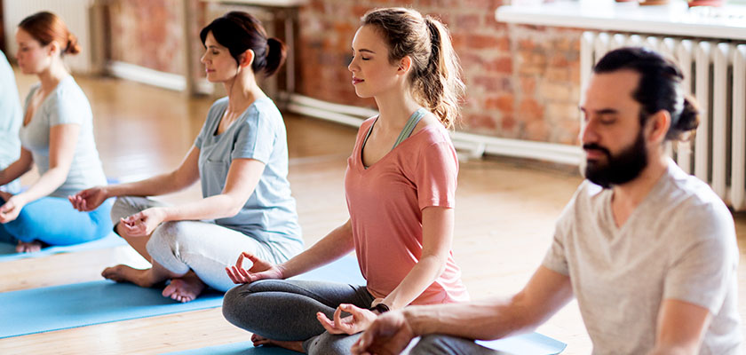 fitness, yoga and healthy lifestyle concept - group of people meditating in lotus pose at studio